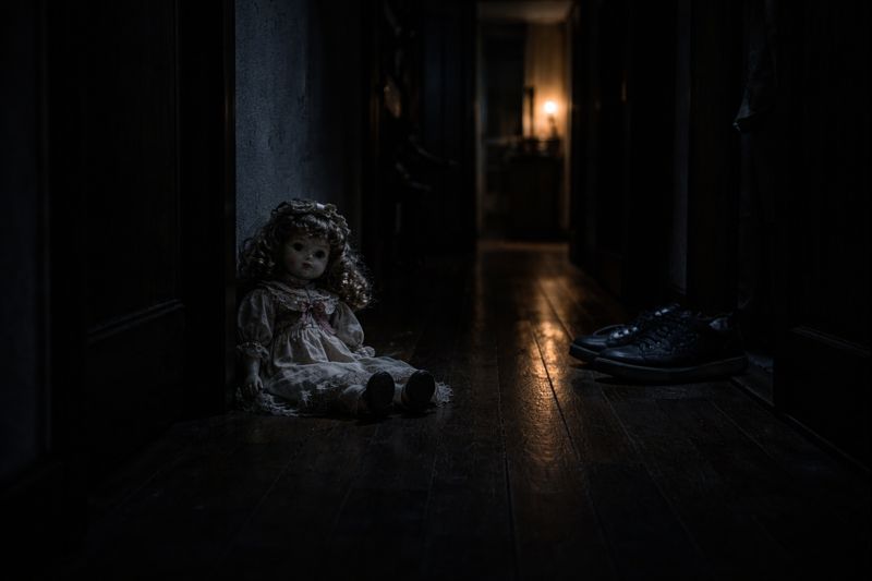 doll sitting in a hallway after whispering a name in the dark
